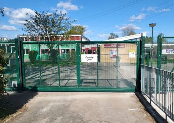 A green security gate with automation in front of a school {{brizy_dc_image_alt imageSrc=